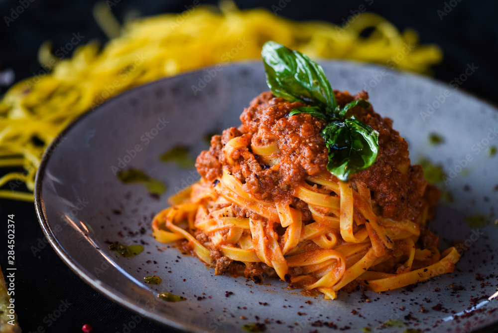 Wall mural delicious italian spaghetti bolognese with minced beef sauce, tomatoes, carrots & fresh basil