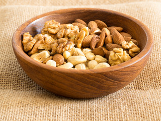 walnuts, cashews and almonds in a wooden plate. healthy foods