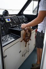 man driving the helm of a ship