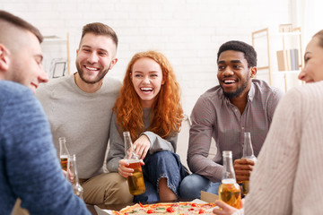 Friends talking, eating pizza and drinking beer