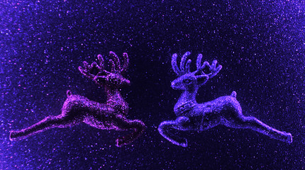 Christmas glitter deer on violet sparkling background. Neon light. Christmas concept.