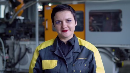 Portrait Of Female Engineer Operating CNC Machinery In Factory