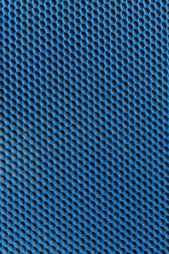 Blaues Gewebe mit elastischer und gleichmäßiger Wabenstruktur und schwarzem Polsteruntergrund als schöner Hintergrund mit copy space