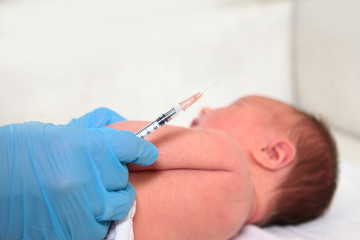 Doctor's hands with a syringe. Resuscitation of newborn children in the hospital. Vaccinations for...