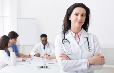 Fototapeta premium Female doctor looking at camera during meeting