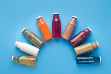 Rainbow of different fruit detox drinks set on blue background