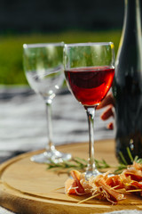 picnic in nature a light meal under wine, on a wooden background two glasses of red wine