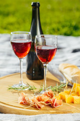 picnic in nature a light meal under wine, on a wooden background two glasses of red wine
