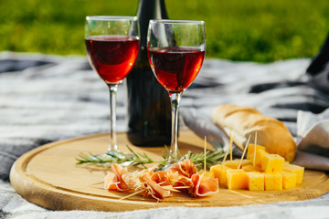 picnic in nature a light meal under wine, on a wooden background two glasses of red wine