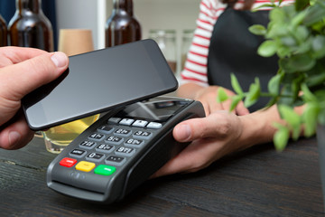 Customer making wireless or contactless payment using smartphone