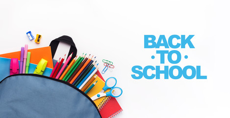 School backpack with colored stationery on white background