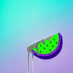 Iridescent shimmering liquid flows down a slice of green watermelon