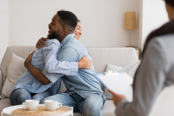 Happy African American Couple Hugging After Reconciling At Psychologist's Office