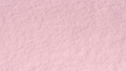 Winter beautiful background - texture snow lit by the morning sun of coral color