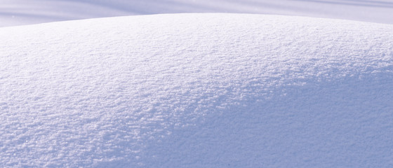 Beautiful winter background - snowy texture with blue and violet tint, wavy surface of winter snowdrift