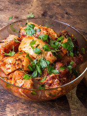 The meat is pickled in a glass bowl on a rustic wooden table, ingredients for cooking meat dishes