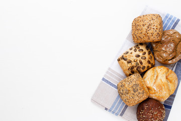 Gold rustic crusty loaves of bread and buns on wooden background. Still life captured from above top view, flat lay.