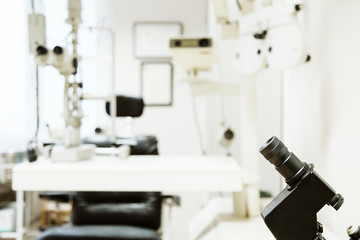 Close-up shot of modern binocular microscope standing on desk of chemistry lab. blurred background.