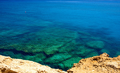  colorful pristine nature of the coast of Cyprus cape cavo greco with clear blue water and yellow rocks