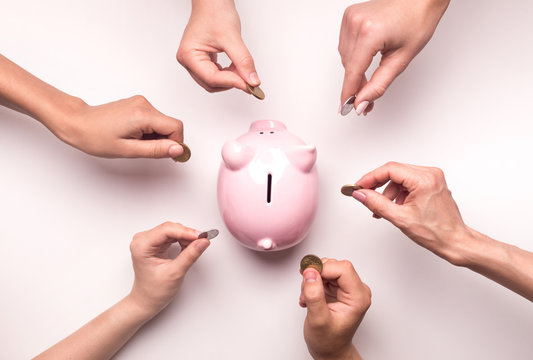 People hands throwing coins in piggy bank for crowdfunding
