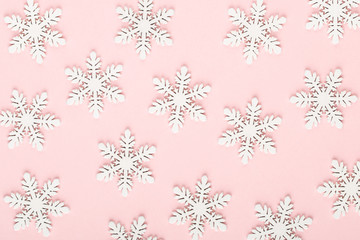 Christmas background. White snow decorations on a pink background.