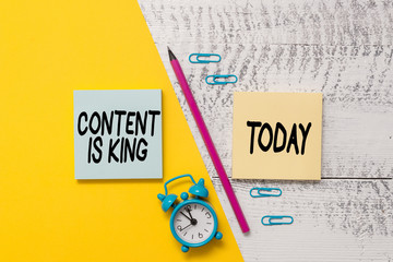 Word writing text Content Is King. Business photo showcasing believe that content is central to the success of a website Notepads marker pen colored paper sheet alarm clock wooden background