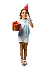 A full-length shot of a Little girl at a birthday party holding a gift shouting with mouth wide open on isolated white background