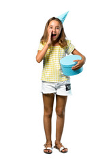 A full-length shot of a Little girl at a birthday party holding a gift shouting with mouth wide open on isolated white background
