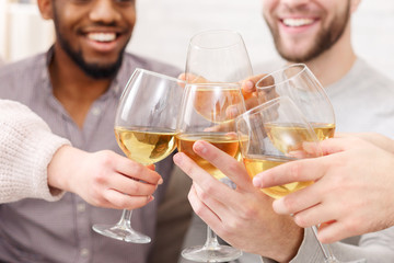 Friends clinking wine glasses, having home party