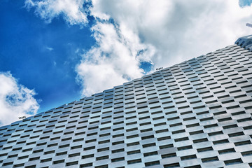 Facade of a modern metal building against a cloudy sky. Bottom view Architecture