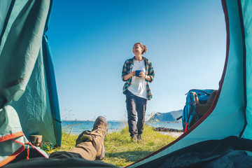 Vue depuis la tente touristique sur une fille heureuse sur la plage, camping sauvage d& 39 aventure en Norvège