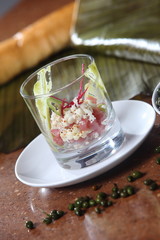 Cocktail of tuna, avocado, capers and chili accompanied by a glass of white wine.