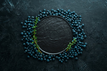 Fresh blueberries on a black stone background. Free copy space.