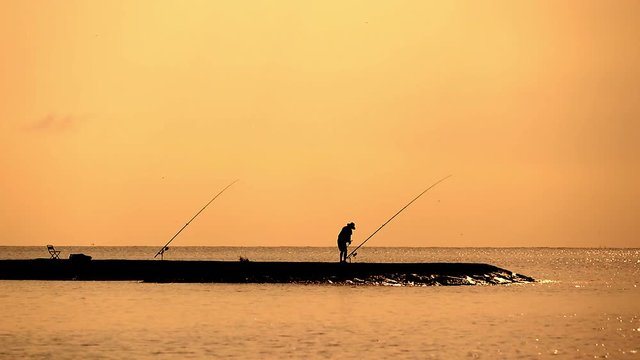 silhouette of the angler at the jetty