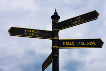 Fototapeta premium Word writing text Hello I Am New. Business photo showcasing introducing oneself in a group as fresh worker or student Road sign on the crossroads with blue cloudy sky in the background