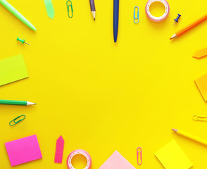Colorful school items as a frame on yellow background. Flat lay, top view. Back to school concept