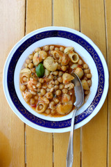 Plate of pasta, chickpea and shrimp stew. Top view.