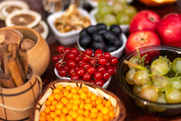 Fototapeta na wymiar Berries and leaves of viburnum, sea buckthorn, pumpkin, walnut, red apple, cinnamon and anise. Autumn vitamins to strengthen the immune system.