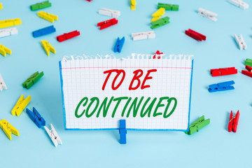Text sign showing To Be Continued. Business photo showcasing indicate that the story continues in the next episode Colored clothespin papers empty reminder blue floor background office pin