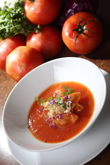 Tomato cream with purple onion and croutons.