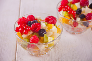 salad with fresh fruits and berries on a bowls on the concreate background