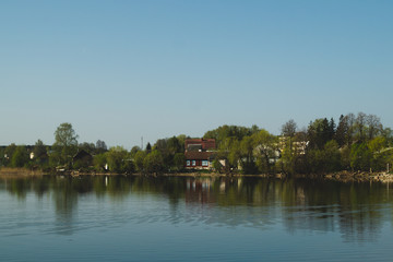 Fototapeta na wymiar Lake house. house on the shore in the village. landscape with reflection on the water