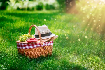Picnic basket with raspberries, grapes and baguette