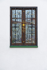 Fototapeta na wymiar Wooden window with wrough iron cross