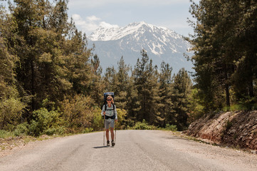 Female traveller walks on a forest road
