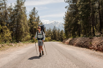 Female traveller walking on a forest road