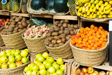 vegetables and fruits in wicker baskets on counter of greengrocery