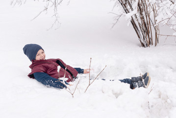 Fototapeta na wymiar school boy having fun in winter in the snow after school