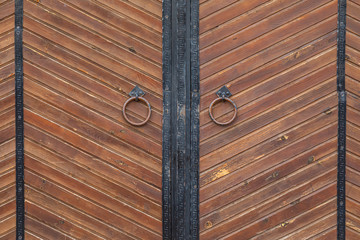 Brown wooden gates with knockers