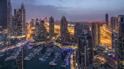 Naklejka premium Aerial top view of Dubai Marina night to day timelapse. Modern towers and traffic on the road